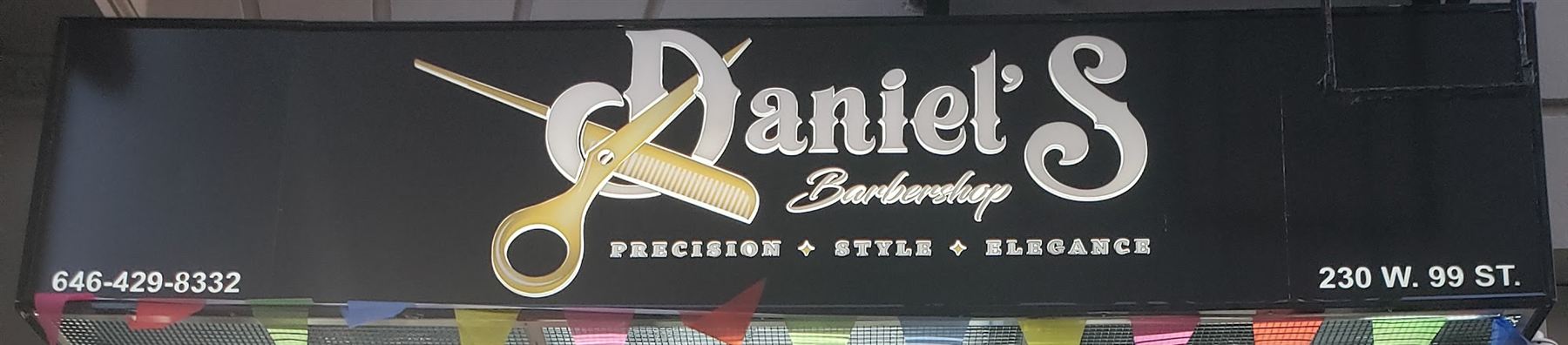 Black storefront sign with the gold scissors-and-comb logo, phone number and 230 W. 99 St.